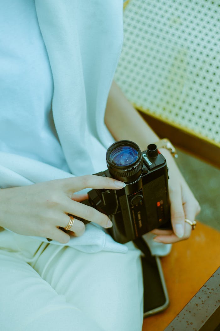 A person holding a vintage camera, showcasing a relaxed and nostalgic photography moment.